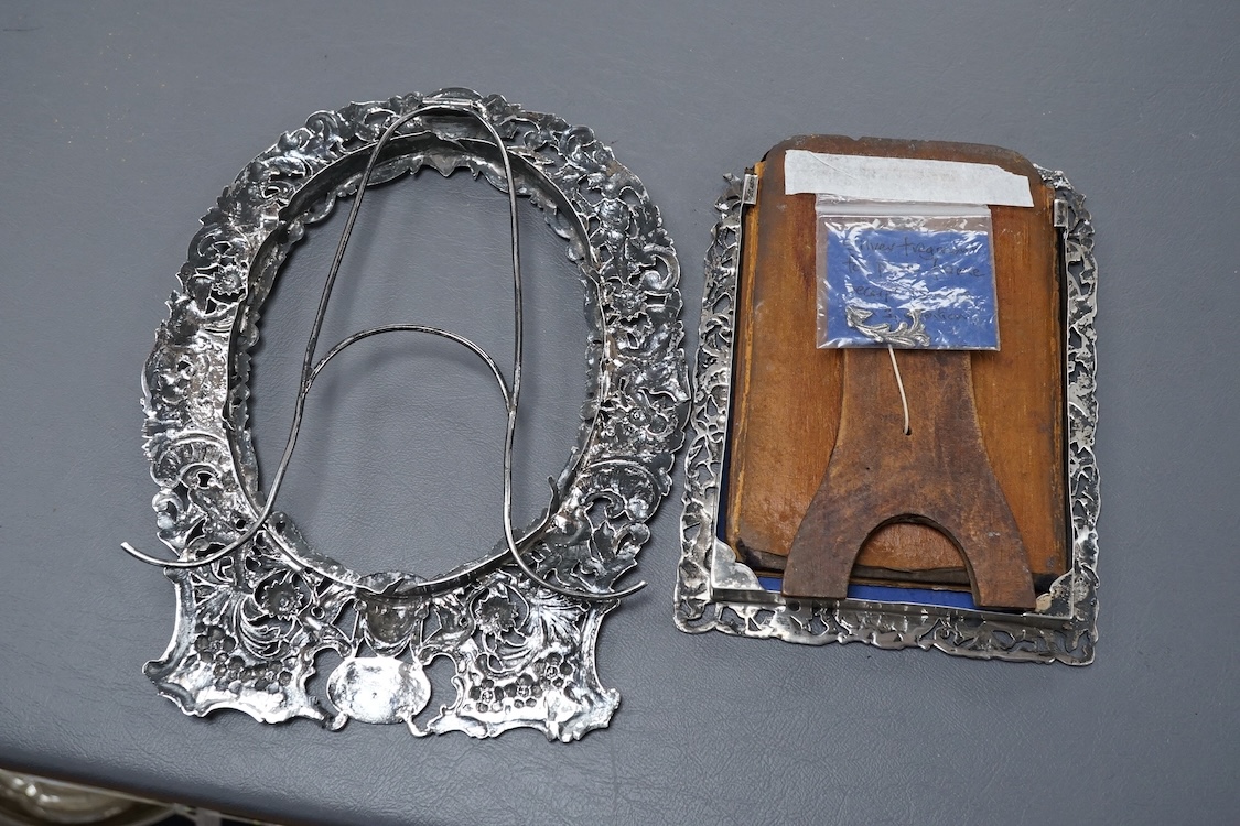 A late Victorian German Hanau silver photograph frame, pierced and decorated with mask, scrolls, figures and animals, import marks for Thomas Glaser, London, 1893, 23.7cm, gross weight 8.7oz, together with one other smal